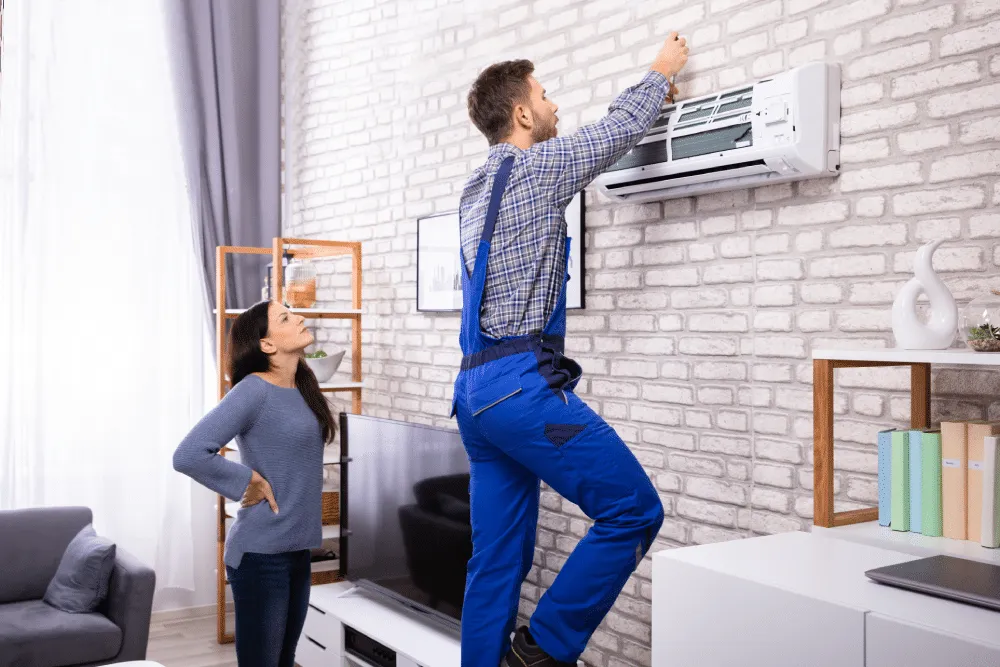 foto di un installatore condizionatore Roma che installa un condizionatore sulla èarete di una casa