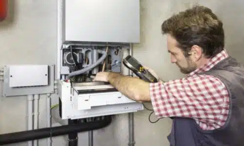 controllo caldaia a gas con addetto che controlla l'uscita dei fumi