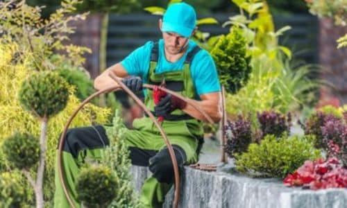 tecnico installa un impianto di irrigazione ad impatto per aree verdi ornamentali